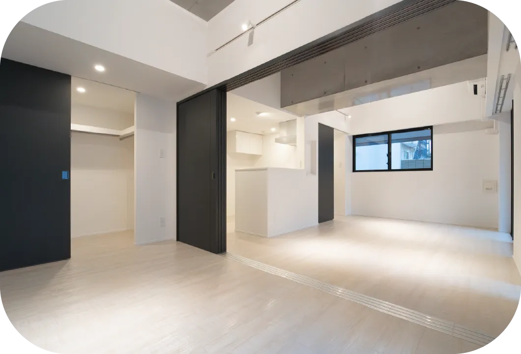 白と黒を基調としたモダンな内装の住宅室内。キッチンやクローゼットを備えた開放的な空間。